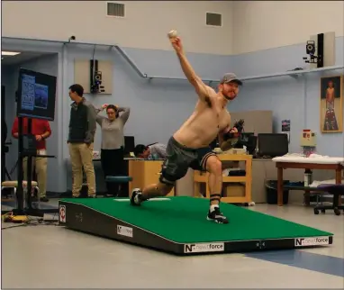  ??  ?? Central Connecticu­t pitcher Michael DeLease throws off a smart mound earlier this year at the Center for Motion Analysis in Farmington, Conn. The new technology allows scientists to better study pitching mechanics to enhance efficiency and prevent injuries. (AP/Pat Eaton-Robb)