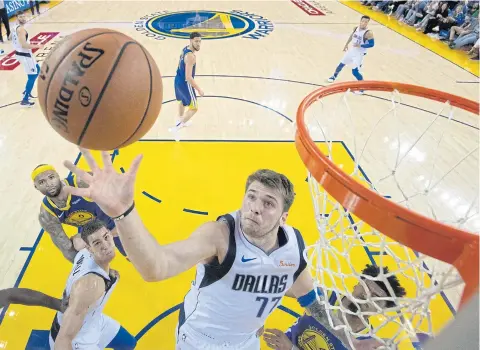  ??  ?? Mavericks forward Luka Doncic grabs a rebound against the Warriors during the second half at Oracle Arena.