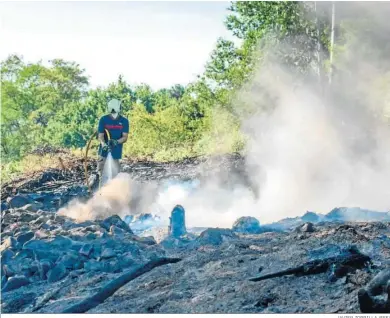  ?? JAVIER ZORRILLA (EFE) ?? Efectivos de bomberos terminan de sofocar el incendio declarado en una zona rural cercana al monte Monforte, en Basauri.