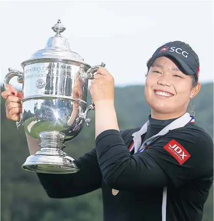  ??  ?? Ariya Jutanugarn holds up the US Women’s Open trophy.