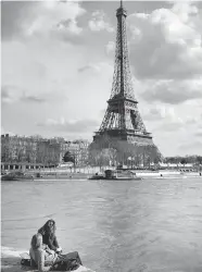  ?? MARTIN BUREAU/AFP/Getty Images ?? If you cycle along the Seine, make sure to take a moment
to relax with a view of the Eiffel Tower.