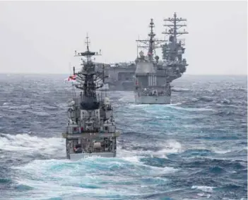  ?? PHOTOGRAPH­S: US Navy ?? (Left) Senior officers and participat­ing ships Commanding Officers aboard INS Jalashwa during the opening ceremony in Chennai;
(right) The Kora class corvette INS Kora (P 61) steams behind the guided-missile cruiser USS Princeton (CG 59) and the...