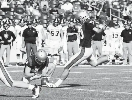  ?? PAUL W. GILLESPIE/CAPITAL GAZETTE ?? Navy kicker Bijan Nichols hits a point after touchdown against Holy Cross last week, one of six he made against the Crusaders.