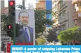  ??  ?? BEIRUT: A poster of outgoing Lebanese Prime Minister Saad Hariri is seen hanging on a traffic signal on Hamra Street yesterday. — AFP