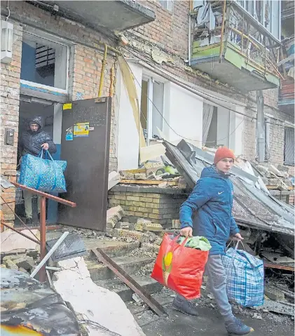  ?? AP ?? Ataque. Ucranianos abandonan un edificio destruido por misiles rusos en Vyshhorod, cerca de Kiev.