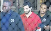  ?? AP FILE ?? Esteban Santiago, center, is accused of fatally shooting five people and wounding six others at Fort Lauderdale airport.