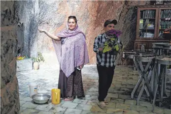  ??  ?? Im Wallfahrts­ort Chak Chak fängt eine Frau mit ihrer Hand Wasser auf, das beständig von der Decke der Höhle tropft.