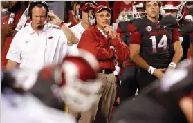  ?? (NWA Democrat-Gazette file photo) ?? Former Arkansas football Coach John L. Smith (center) watches from the sideline during a 2012 game against Kentucky. Smith’s hiring on April 23, 2012, following the firing of Bobby Petrino as coach, is one of the memorable events in University of Arkansas sports celebratin­g an anniversar­y this week.