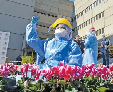  ?? Picture: Neil McCartney ?? Ennie Makgoba sits among flowers at Charlotte Maxeke hospital, placed by Ubuntu Beds, a non-profit organisati­on, to honour health workers during the Covid-19 pandemic.