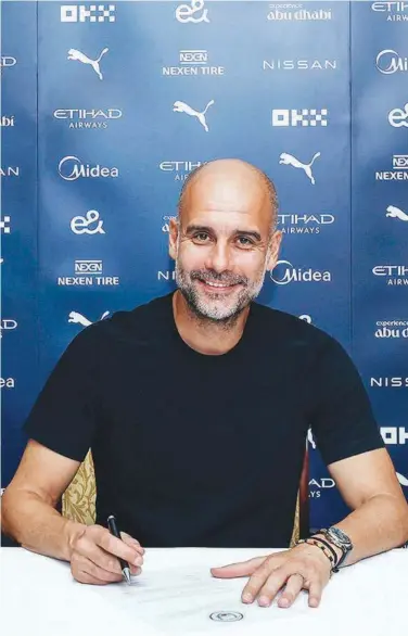  ?? Courtesy: Manchester City Twitter ?? Pep Guardiola signs a new agreement with Manchester City.