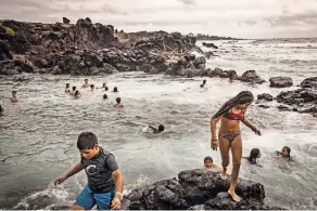  ??  ?? Archaeolog­ists are rushing to find answers about early civilizati­on on Easter Island, as the seas keep ever rising. Rano Raraku, top, one of the island’s quarries, where partially finished statues were abandoned. Above, swimmers in Hanga Roa.