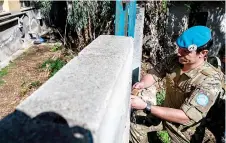  ?? ?? Sapper Aaron Joyce from the British Army’s 71 Engineer Regiment unlocks a door while patrolling along the buffer zone.