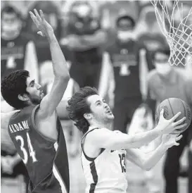  ?? JOHN MUNSON/AP ?? Colgate’s Jack Ferguson drives past Loyola Maryland’s Santi Aldama during the Patriot League tournament final Sunday in Hamilton, New York.