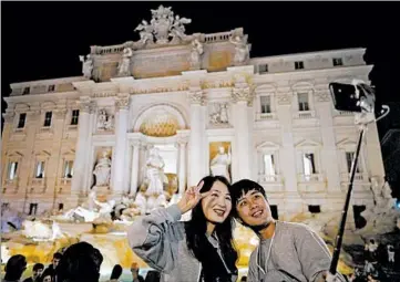  ?? ANDREW MEDICHINI/AP PHOTOS ?? It’s OK to take a photo at Rome’s Trevi Fountain. But if you dare to bathe in it, there are consequenc­es under a new law.