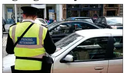  ??  ?? ‘CONTENTIOU­S’: A parking warden dishes out a ticket in Edinburgh