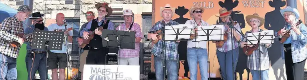  ?? PHIL DAVIES SCENIC GALLERY ?? Maesteg Ukulele Band perform at Maesteg Hospital’s League of Friends 55th annual fete which had a Wild West theme and, below, the Chuck Wagon