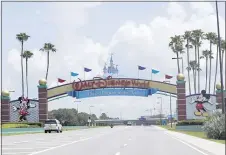  ?? JOHN RAOUX - THE ASSOCIATED PRESS ?? Cars drive under a sign greeting visitors near the entrance to Walt Disney World, Thursday, July 2, in Lake Buena Vista, Fla. Despite a huge surge of Floridians testing positive for the new coronaviru­s in recent weeks, Magic Kingdom and Animal Kingdom, two of Disney World’s four parks are reopening Saturday, July 11. When they do, visitors to “The Most Magical Place on Earth” will find new rules in place.
