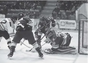  ?? [ALI WILSON / OBSERVER] ?? Goalie Tyler Mazzocato protects the puck with a little help from teammates Damian Figueira and Kurtis Goodwin, taking away a chance from the Siskins.