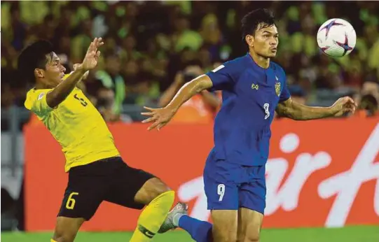  ?? [ FOTO ASYRAF HAMZAH/BH ] ?? Syazwan (kiri) mengasak pemain Thailand, Adisak Kraisorn pada perlawanan separuh akhir pertama Piala AFF 2018.