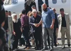  ?? AFP ?? Martin Griffiths, centre, arrives at Sanaa internatio­nal airport yesterday to begin preparatio­ns for peace talks in Sweden