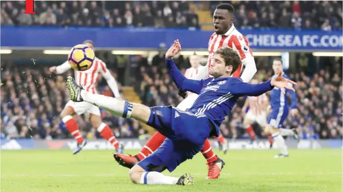  ?? —AP ?? LONDON: Chelsea’s Marcos Alonso, left, and Stoke City’s Mame Biram Diouf battle for the ball during their English Premier League soccer match at Stamford Bridge, London, yesterday.