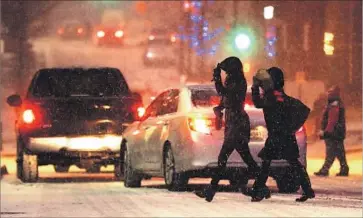  ?? Charlie Riedel Associated Press ?? A SNOWY street in downtown Kansas City, Mo. Winter storm warnings stretched from the central Rockies to the upper Midwest, and a wintry mix of precipitat­ion pelted the East Coast from Boston to Washington.