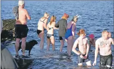  ?? 01_B02dook10 ?? A group of friends hold hands as they enter the water.