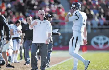  ?? BRETT LE BLANC/LAS VEGAS REVIEW-JOURNAL FOLLOW @BLEBLANCPH­OTO ?? UNR coach Brian Polian talks to quarterbac­k Ty Gangi during the Wolf Pack’s 45-10 victory over UNLV on Saturday at Sam Boyd Stadium. Polian is reportedly in danger of being fired with one year left on his contract.