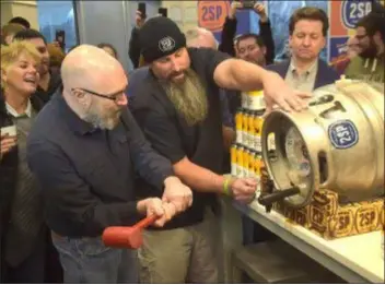  ?? PETE BANNAN DIGITAL FIRST MEDIA ?? Wawa Product Developmen­t Manager Michael McLaughlin and 2SP head brewer Bob Barrar tap the Wawa Winter Reserve Coffee Stout Thursday during an event at the Chadds Ford convenienc­e store location.