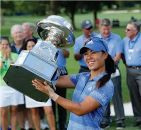  ?? Associated Press ?? Danielle Kang raises the championsh­ip trophy Sunday after winning the Women's PGA Championsh­ip golf tournament at Olympia Fields Country Club in Olympia Fields, Ill.