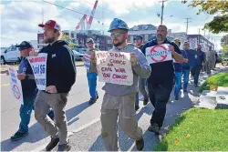  ?? JOSH REYNOLDS/ASSOCIATED PRESS ?? Justin Paetow, center, a tin shop worker at Bath Iron Works, takes part in a demonstrat­ion against COVID-19 vaccine mandates on Friday in Bath, Maine. Some workers are quitting their jobs in defiance of vaccine mandates.