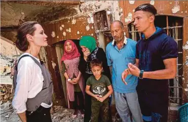  ?? AFP PIC ?? United
Nations High Commission­er for Refugees special envoy Angelina Jolie (left) speaking to Mohamed and his family during a visit to the Old City in western Mosul on Saturday.