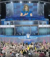  ??  ?? FIRST LADY Michelle Obama speaks with the video boards as a backdrop. The precise shade of the digital woven pattern changes from speaker to speaker.