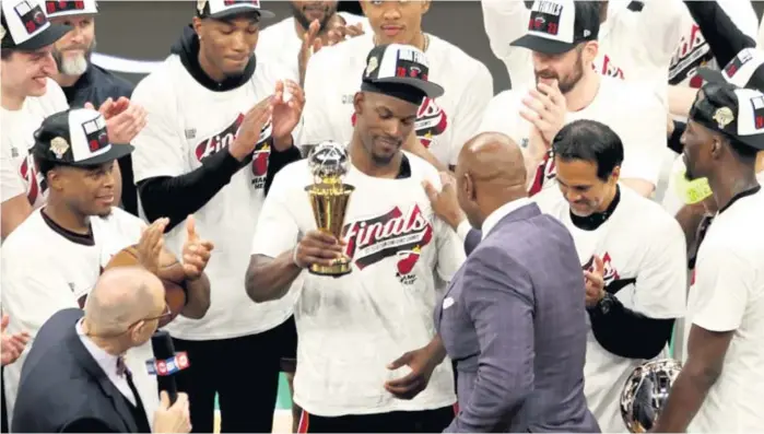  ?? ADAM GLANZMAN/GETTY IMAGES ?? Hall of Famer Alonzo Mourning presents Heat star Jimmy Butler with the Larry Bird Trophy at TD Garden after Butler was named the Eastern Conference finals MVP.