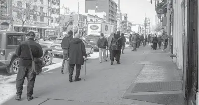  ?? ANDREW SENG/THE NEW YORK TIMES ?? People wait for meals March 22 at the Bowery Mission in Manhattan. Some Americans who would benefit most from the government’s stimulus payments amid the pandemic are having the hardest time getting it for a variety of reasons.