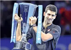  ??  ?? Serbia’s Novak Djokovic poses with the trophy after winning the ATP World Tour Finals tennis tournament in London following the withdrawal of Switzerlan­d’s Rodger Federer from the final match due to an injury. - AFP photo