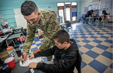  ?? JIM WEBER/THE NEW MEXICAN ?? National Guard Spc. James Quintana, 18, works with Desmond Hice on a math exercise Tuesday in Korrie Lopez’s fifth grade class in Española. Quintana is filling in as a substitute, mostly in physical education, since February.