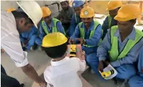  ??  ?? Labourers at the Dubai Hills Estate receive ‘thank you’ notes and food packs on Monday from three-year-old Miraan and his parents Gauri and Mayur Hotwani.