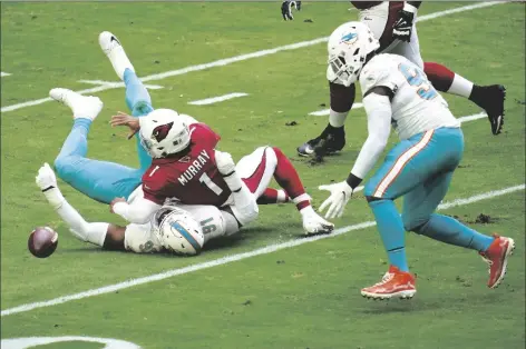  ?? ASSOCIATED PRESS ?? MIAMI DOLPHINS DEFENSIVE END EMMANUEL OGBAH (91) forces Arizona Cardinals quarterbac­k Kyler Murray (1) to fumble during the first half of a game on Sunday in Glendale. Dolphins’ defensive end Shaq Lawson (right) recovered the ball for a touchdown.