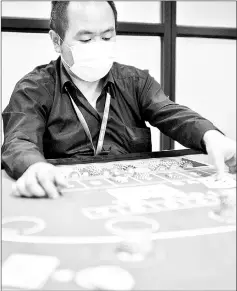  ??  ?? Practising skills in baccarat at the Japan Casino School in Tokyo.