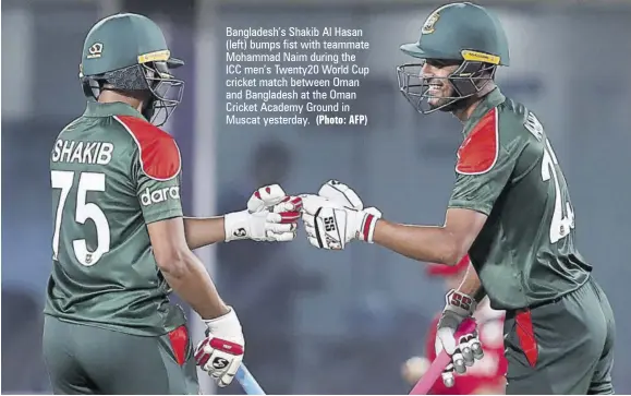 ?? (Photo: AFP) ?? Bangladesh’s Shakib Al Hasan (left) bumps fist with teammate Mohammad Naim during the ICC men’s Twenty20 World Cup cricket match between Oman and Bangladesh at the Oman Cricket Academy Ground in Muscat yesterday.