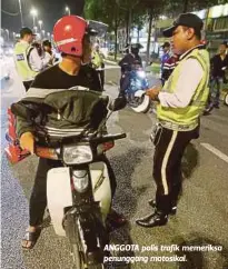  ??  ?? ANGGOTA polis trafik memeriksa penunggang motosikal.