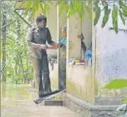  ?? AP ?? A police constable tries to persuade an 80yearold woman to move from her partiallys­ubmerged house in Chengannur to a government­run shelter on Sunday.