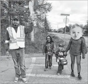  ?? ELIZABETH PATTERSON/CAPE BRETON POST ?? Eldon John Matthews holds up the stop sign to make sure trick-or-treaters in Membertou have a safe Halloween. Left to right are Matthews, Preston Helle, 7, Sean Helle, 4, and Gaby Doucette, 16.