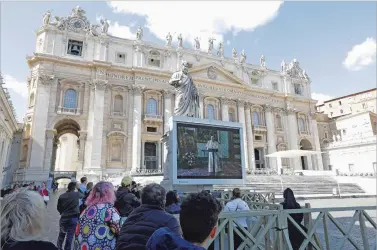  ?? ANDREW MEDICHINI/ASSOCIATED PRESS ?? A smattering of the faithful watch Pope Francis deliver the Angelus prayer on a large screen Sunday in St. Peter’s Square at the Vatican. The pope described being in lockdown due to the virus as feeling like he was ‘in a cage.’