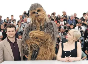  ?? ARTHUR MOLA/THE ASSOCIATED PRESS ?? Actor Alden Ehrenreich, left, Chewbacca and actress Emilia Clarke at the recent Cannes Film Festival.
