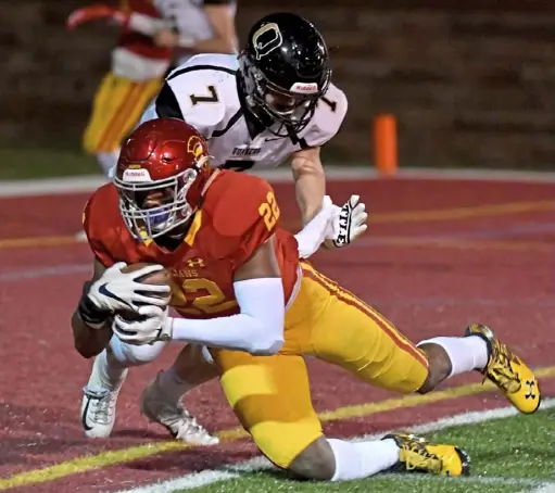  ?? Matt Freed/Post-Gazette ?? North Catholic’s Nikhai Hill-Green scores a touchdown in front of Quaker Valley’s Ryan Jackovic Friday night.