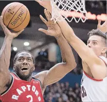  ?? JONATHAN HAYWARD THE CANADIAN PRESS ?? Toronto Raptors forward Kawhi Leonard, left, fights for control of the ball with Portland Trail Blazers forward Zach Collins in pre-season NBA action in Vancouver on Saturday. Leonard had 12 points in the Raptors’ 122-104 win over the Trail Blazers in his first game since Jan. 13.