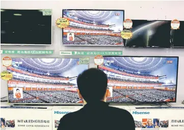  ??  ?? A man watches a broadcast of Xi delivering his speech during the opening of the 19th National Congress of the Communist Party of China, at an electronic­s store in Liuzhou, Guangxi Zhuang Autonomous Region, China. — Reuters photo