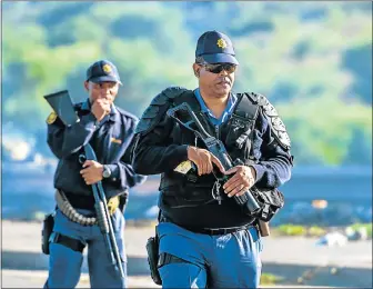  ?? Picture: EUGENE COETZEE ?? ON GUARD: Police keep an eye on a service delivery protest in the northern areas yesterday